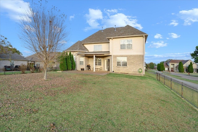 rear view of property featuring a patio and a yard