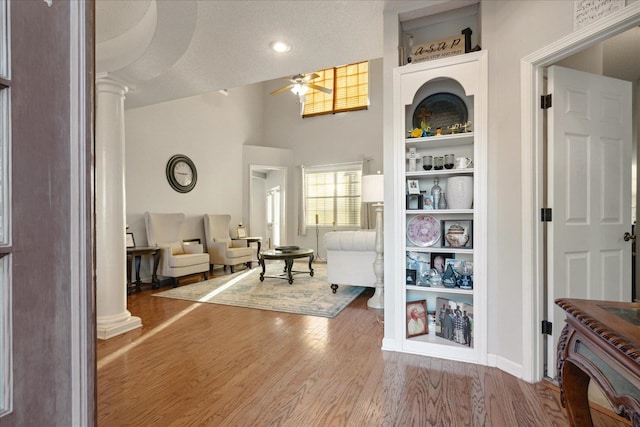 sitting room featuring ceiling fan, decorative columns, a textured ceiling, and hardwood / wood-style floors