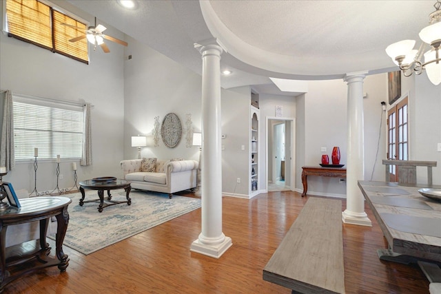 living room with a towering ceiling, hardwood / wood-style floors, a healthy amount of sunlight, and a textured ceiling