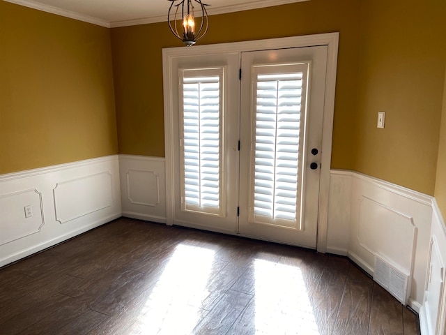 entryway with crown molding, a notable chandelier, and dark hardwood / wood-style flooring