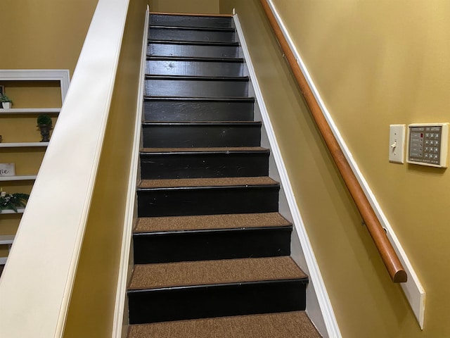 staircase featuring a mail area and carpet flooring