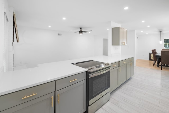 kitchen with gray cabinets, stainless steel electric stove, hanging light fixtures, and ceiling fan