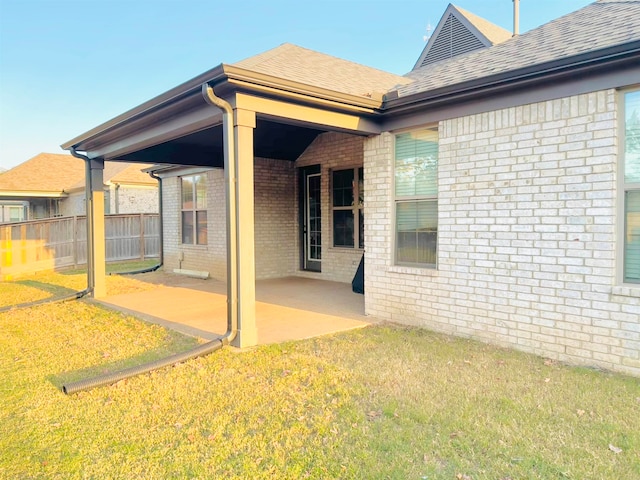 back of property with a lawn and a patio