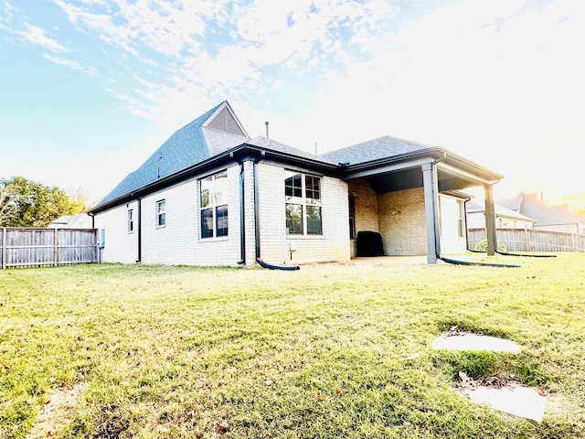 rear view of house featuring a patio area and a yard