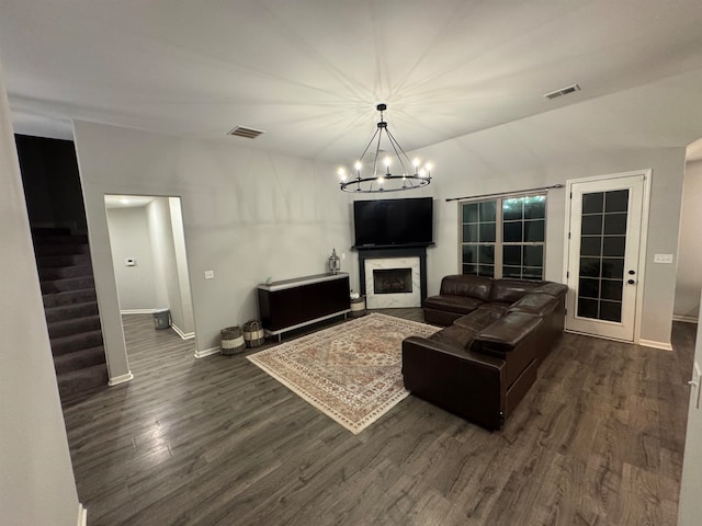 living room with dark hardwood / wood-style floors and an inviting chandelier