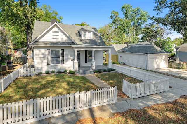 view of front of house with a garage, a front lawn, and an outbuilding