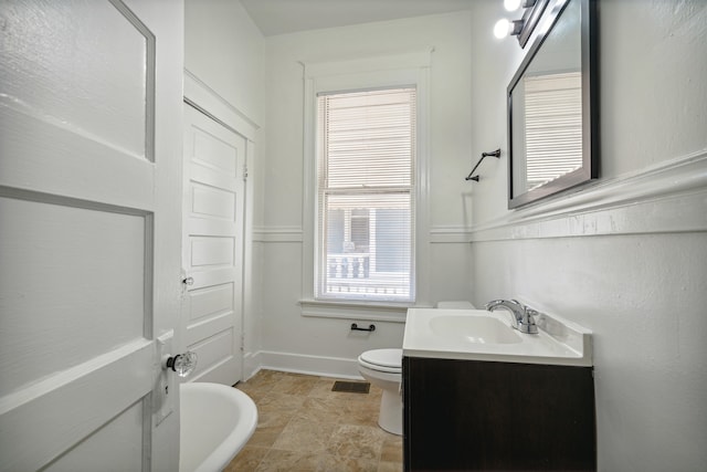 bathroom with vanity, a healthy amount of sunlight, and toilet