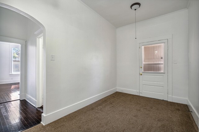 2186 Monroe Ave, Memphis, TN 38104 - empty room with arched walkways, baseboards, crown molding, and dark carpet