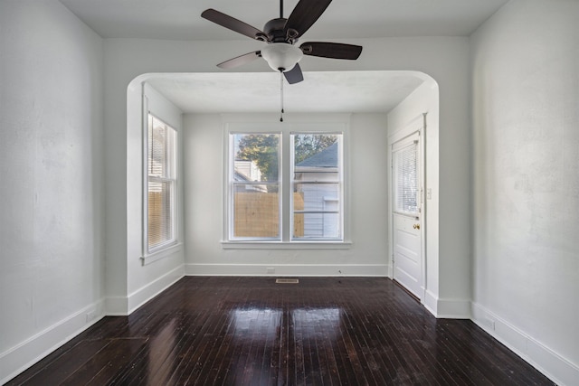 2186 Monroe Ave, Memphis, TN 38104 - unfurnished dining area with hardwood / wood-style flooring, baseboards, ceiling fan, and arched walkways