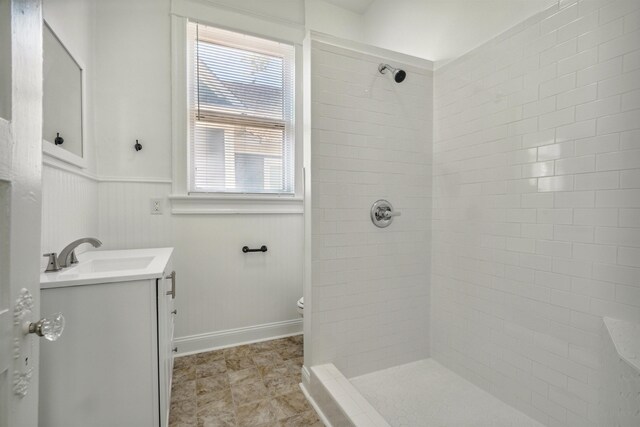 2186 Monroe Ave, Memphis, TN 38104 - bathroom featuring vanity, a tile shower, a wainscoted wall, and toilet