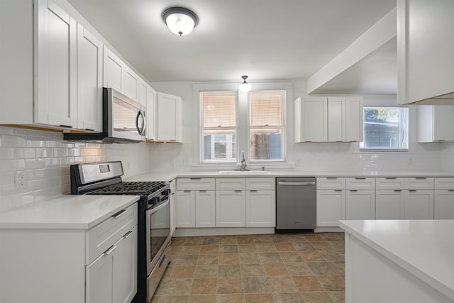 kitchen featuring white cabinetry, stainless steel appliances, decorative backsplash, and sink