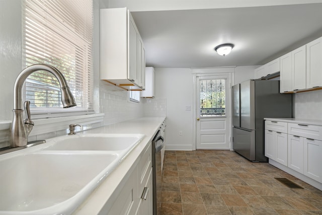 kitchen featuring appliances with stainless steel finishes, white cabinets, sink, and a wealth of natural light