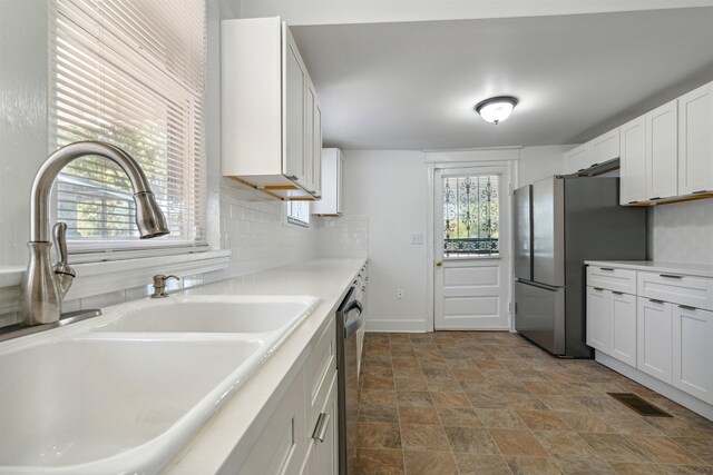 2186 Monroe Ave, Memphis, TN 38104 - kitchen with a sink, stone finish flooring, stainless steel appliances, tasteful backsplash, and light countertops