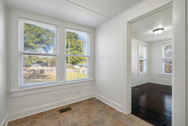 empty room with a healthy amount of sunlight and hardwood / wood-style flooring