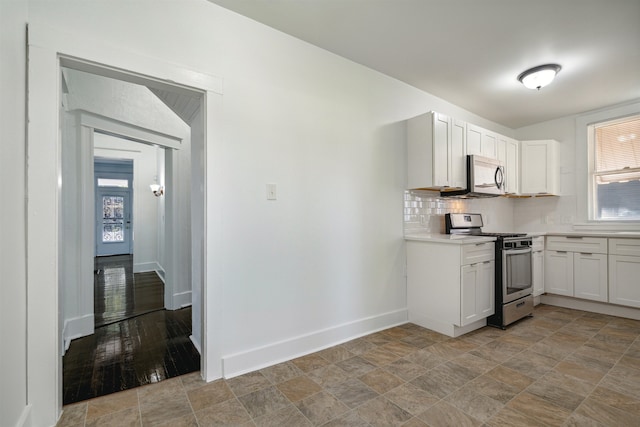 kitchen with backsplash, appliances with stainless steel finishes, light hardwood / wood-style flooring, and white cabinets