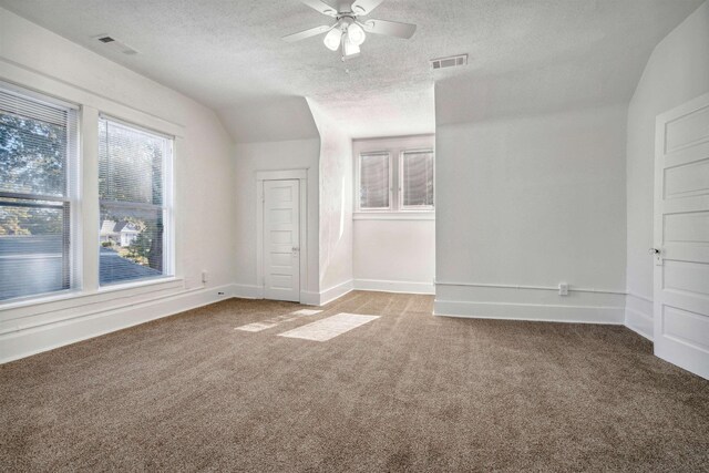 2186 Monroe Ave, Memphis, TN 38104 - spare room with a textured ceiling, carpet flooring, a ceiling fan, vaulted ceiling, and baseboards