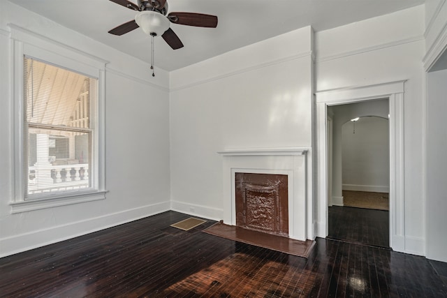 unfurnished living room featuring dark wood-type flooring and ceiling fan