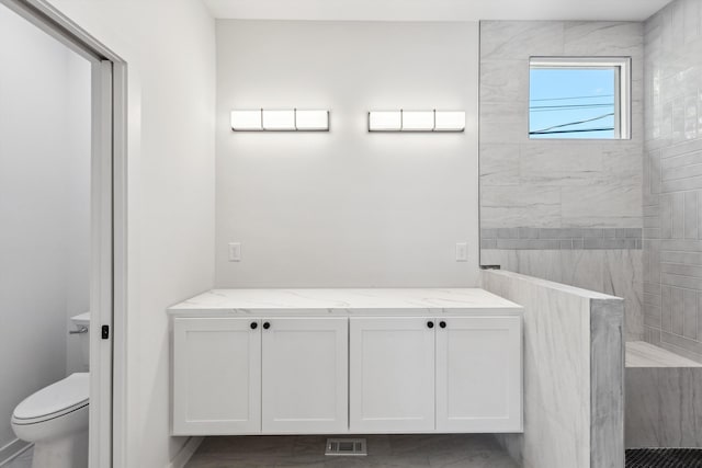bathroom featuring toilet, visible vents, and a walk in shower