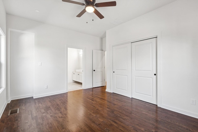 unfurnished bedroom with connected bathroom, wood finished floors, a closet, visible vents, and baseboards