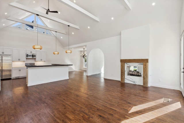 living area featuring a fireplace, beam ceiling, and high vaulted ceiling