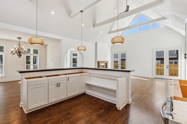 kitchen with hanging light fixtures, high vaulted ceiling, beam ceiling, a notable chandelier, and dark wood-style flooring