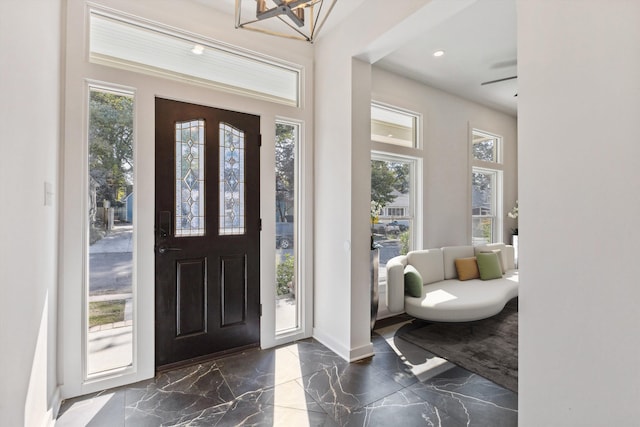 foyer featuring a chandelier, marble finish floor, baseboards, and recessed lighting