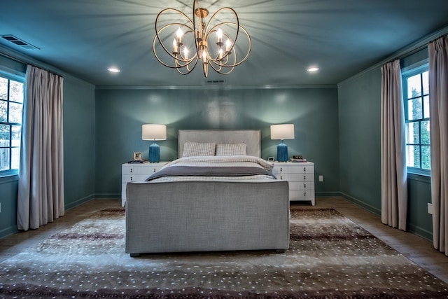 bedroom with crown molding, wood-type flooring, and a chandelier