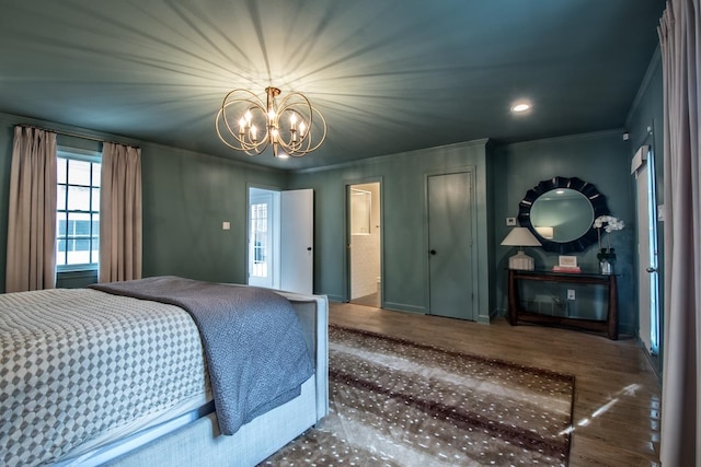 bedroom with crown molding, a notable chandelier, and hardwood / wood-style floors