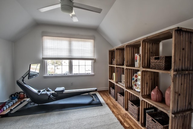 workout room with ceiling fan, vaulted ceiling, and hardwood / wood-style floors