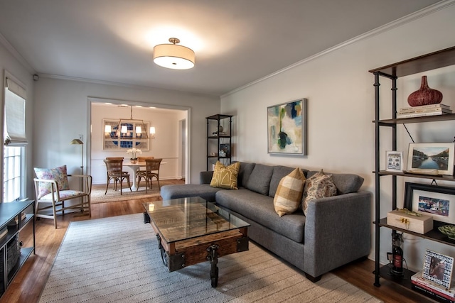 living room featuring an inviting chandelier, crown molding, and wood-type flooring