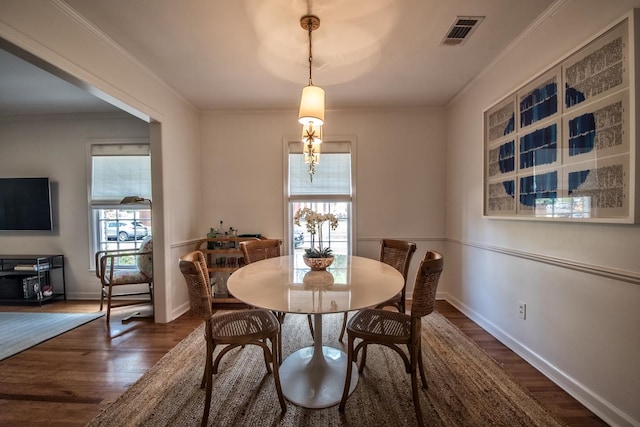 dining area featuring crown molding, dark hardwood / wood-style floors, and a healthy amount of sunlight