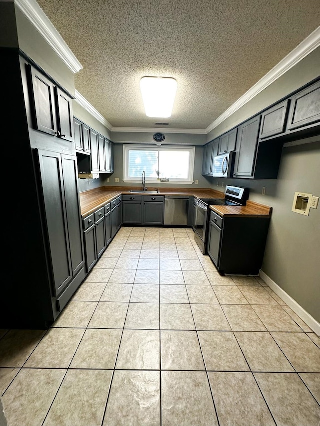 kitchen featuring crown molding, butcher block counters, stainless steel appliances, and light tile patterned floors