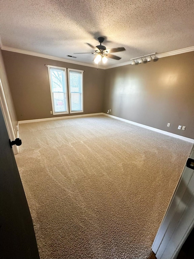 empty room with a textured ceiling, crown molding, carpet flooring, and ceiling fan