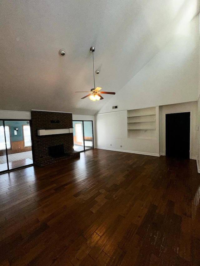 unfurnished living room featuring dark wood-type flooring, vaulted ceiling, a fireplace, and built in features