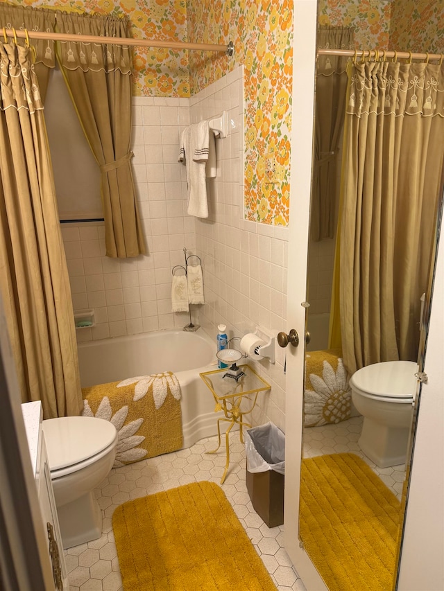 bathroom featuring toilet, tile patterned floors, shower / bath combo, and tile walls