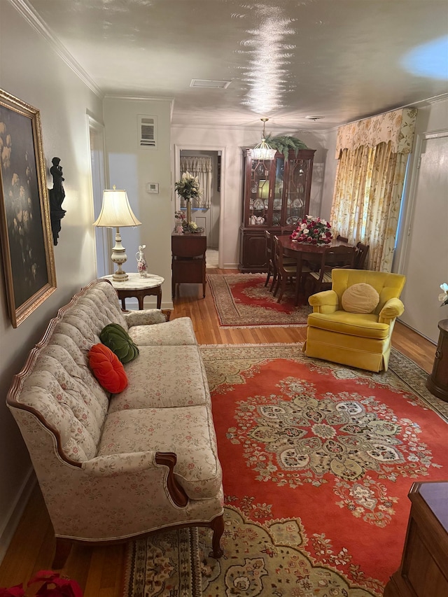 living room with ornamental molding, hardwood / wood-style floors, and a chandelier