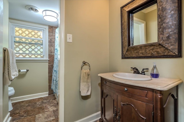 bathroom with toilet, vanity, and a shower with shower curtain