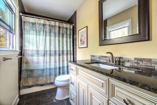 full bathroom with a wealth of natural light, vanity, toilet, and tile patterned floors