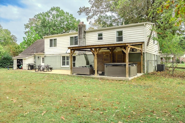 rear view of house with a hot tub, an outdoor living space, a lawn, central AC, and a patio area