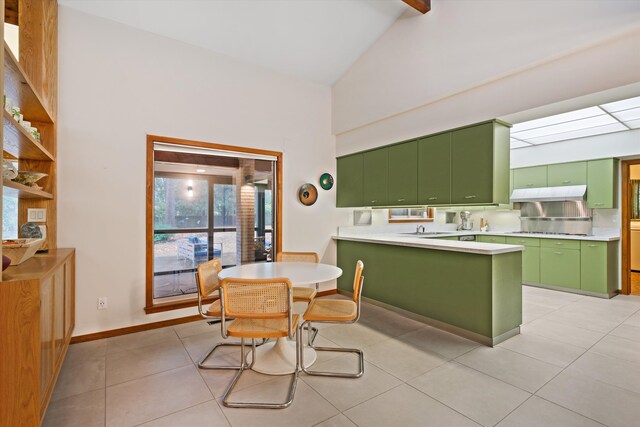 kitchen with green cabinetry, kitchen peninsula, stainless steel stovetop, sink, and light tile patterned floors