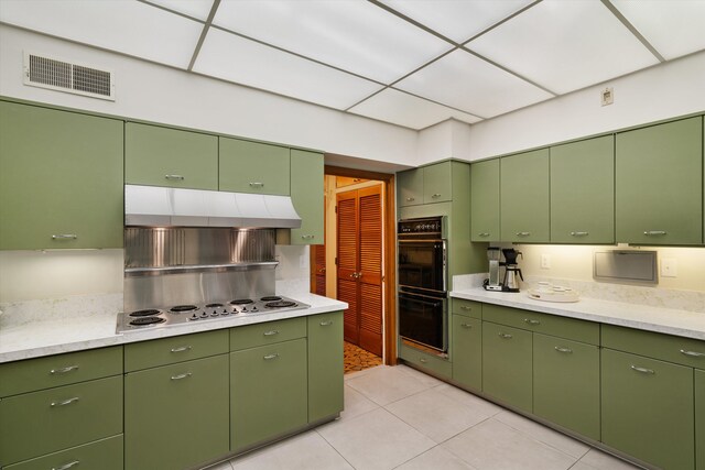 kitchen featuring a paneled ceiling, white electric cooktop, double oven, and light tile patterned flooring