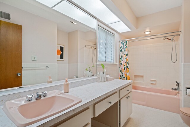 full bathroom featuring tile walls, vanity, shower / bath combination with curtain, and toilet