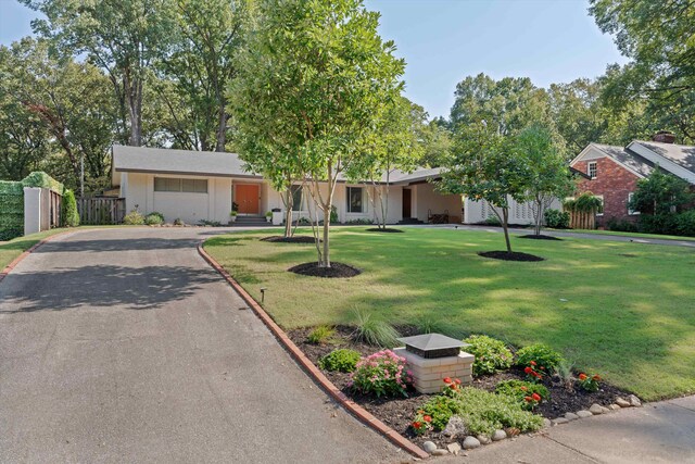 single story home featuring a garage and a front lawn