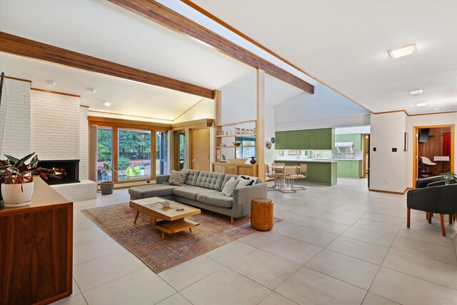 living room featuring a fireplace, light tile patterned flooring, sink, and lofted ceiling with beams