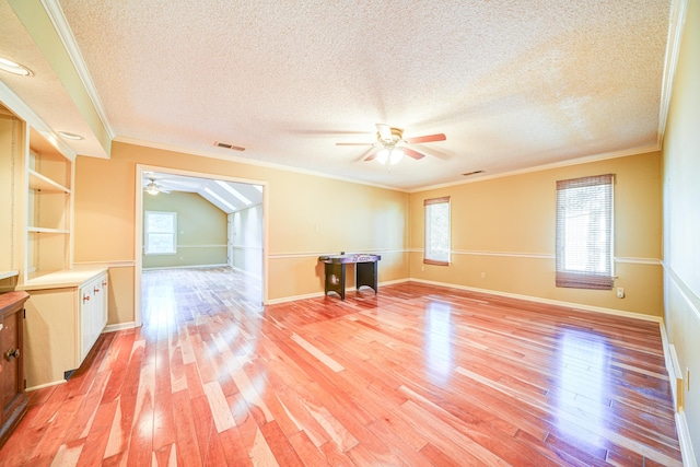 unfurnished living room featuring light hardwood / wood-style floors, a textured ceiling, and ornamental molding