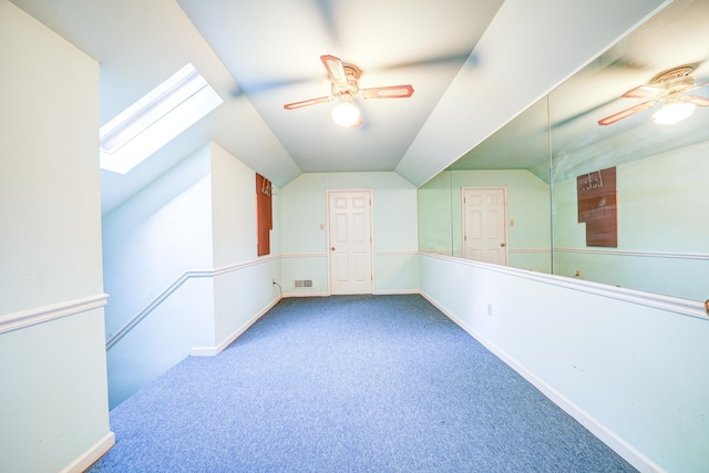 bonus room featuring lofted ceiling with skylight, carpet floors, and ceiling fan