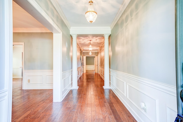 corridor featuring ornamental molding, ornate columns, and wood-type flooring