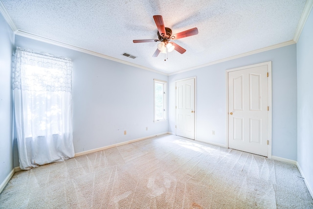 unfurnished bedroom with light carpet, crown molding, a textured ceiling, and ceiling fan