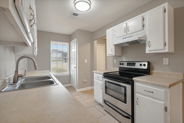 kitchen featuring sink, light tile patterned flooring, stainless steel range with electric stovetop, a textured ceiling, and white cabinetry