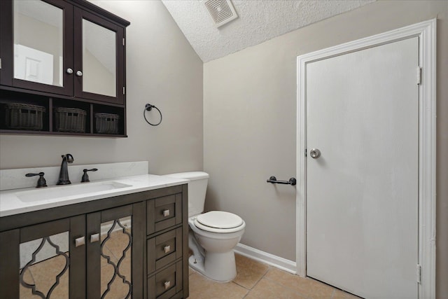 bathroom with vanity, toilet, a textured ceiling, and tile patterned flooring